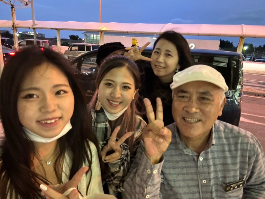 那覇空港に到着後、観光タクシーのドライバーと笑顔で合流するお客様